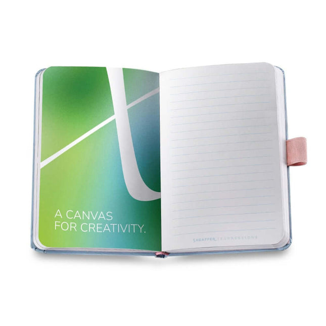 Open Sheaffer Expressions notebook showing creative green design and ruled pages for note-taking.