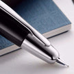 Pilot Capless Decimo Black Fountain Pen close-up with rhodium accents and nib on a notebook.