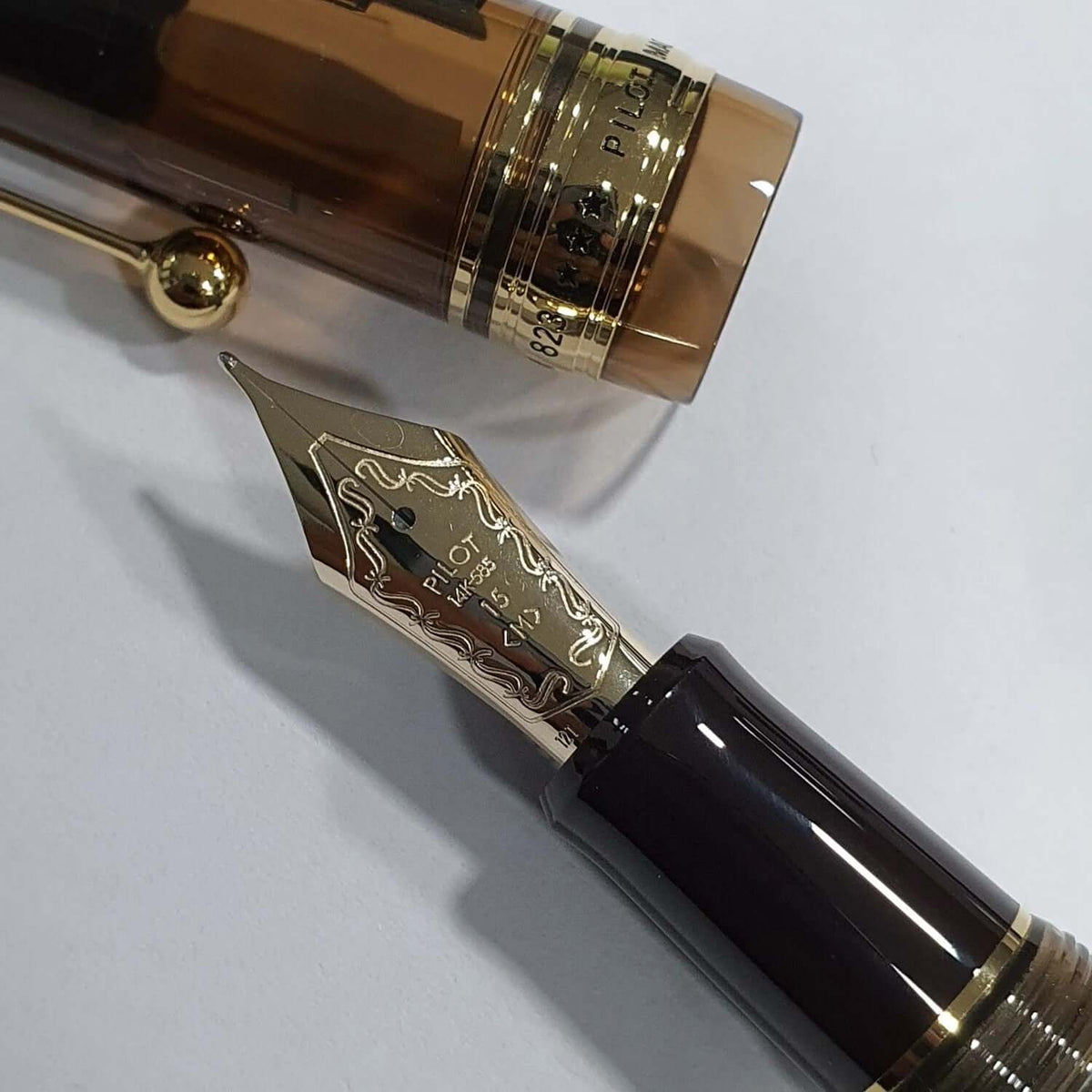 Pilot Custom 823 Amber Brown GT Fountain Pen close-up showing golden nib and barrel details.