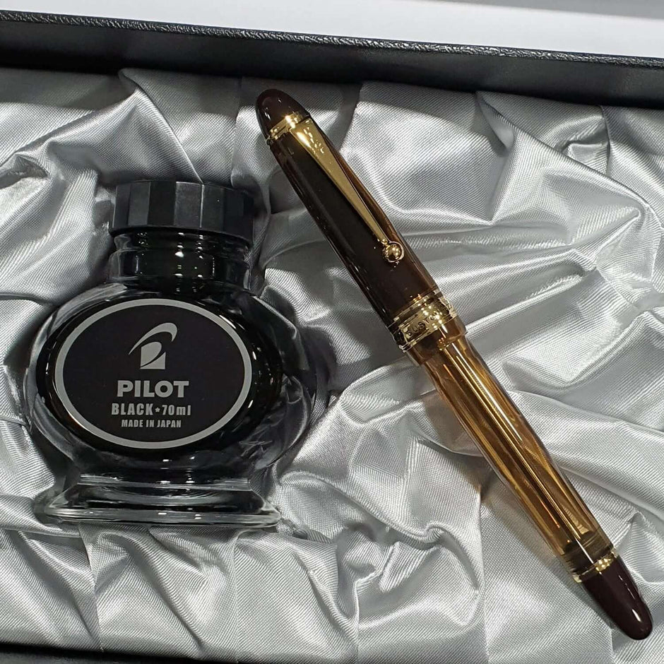Pilot Custom 823 Amber Brown GT Fountain Pen and Pilot black ink bottle in elegant packaging.