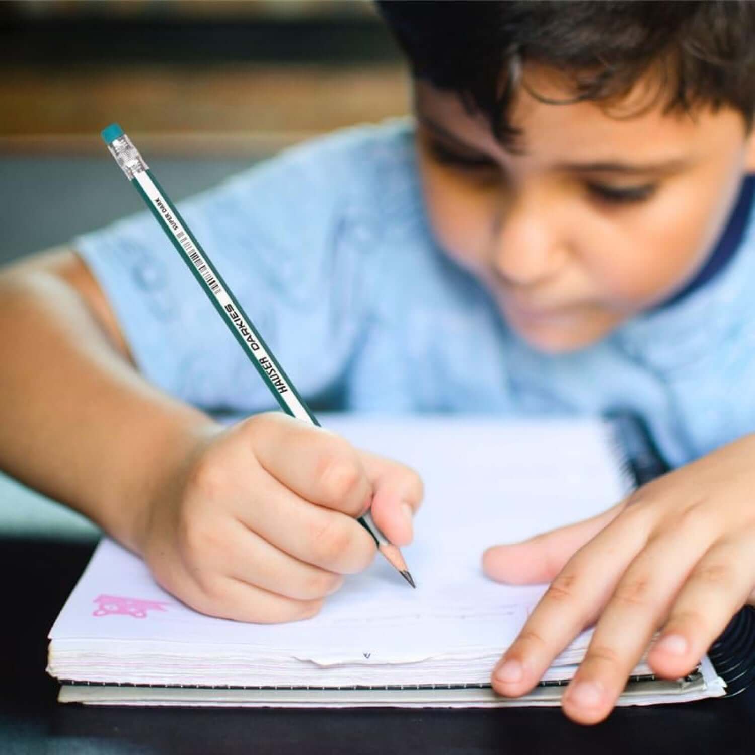 Hauser Artz Darkies Super Dark Pencil | Includes Scale, Eraser and Sharpener in use by a child writing.