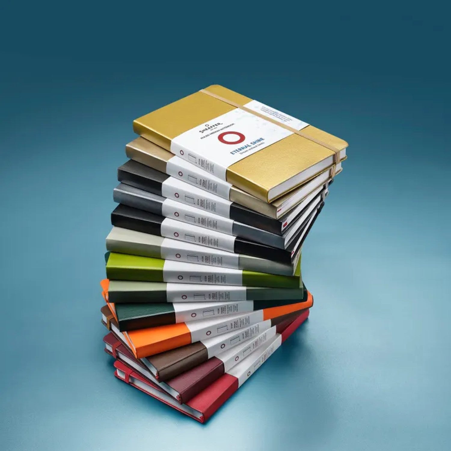 Stack of colorful Sheaffer Echoes Of Red 90 GSM Notebooks showcasing vibrant covers and packaging.