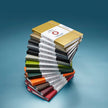 Stack of colorful Sheaffer Echoes Of Red 90 GSM Notebooks showcasing vibrant covers and packaging.
