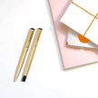 Parker Vector Gold Roller Ball Pen and Ball Pen with Card Holder elegantly displayed with stylish notebooks.