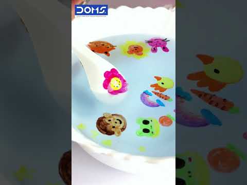 DOMS Floating Markers Set of 12 Shades showing colorful designs floating in water with a flat spoon.