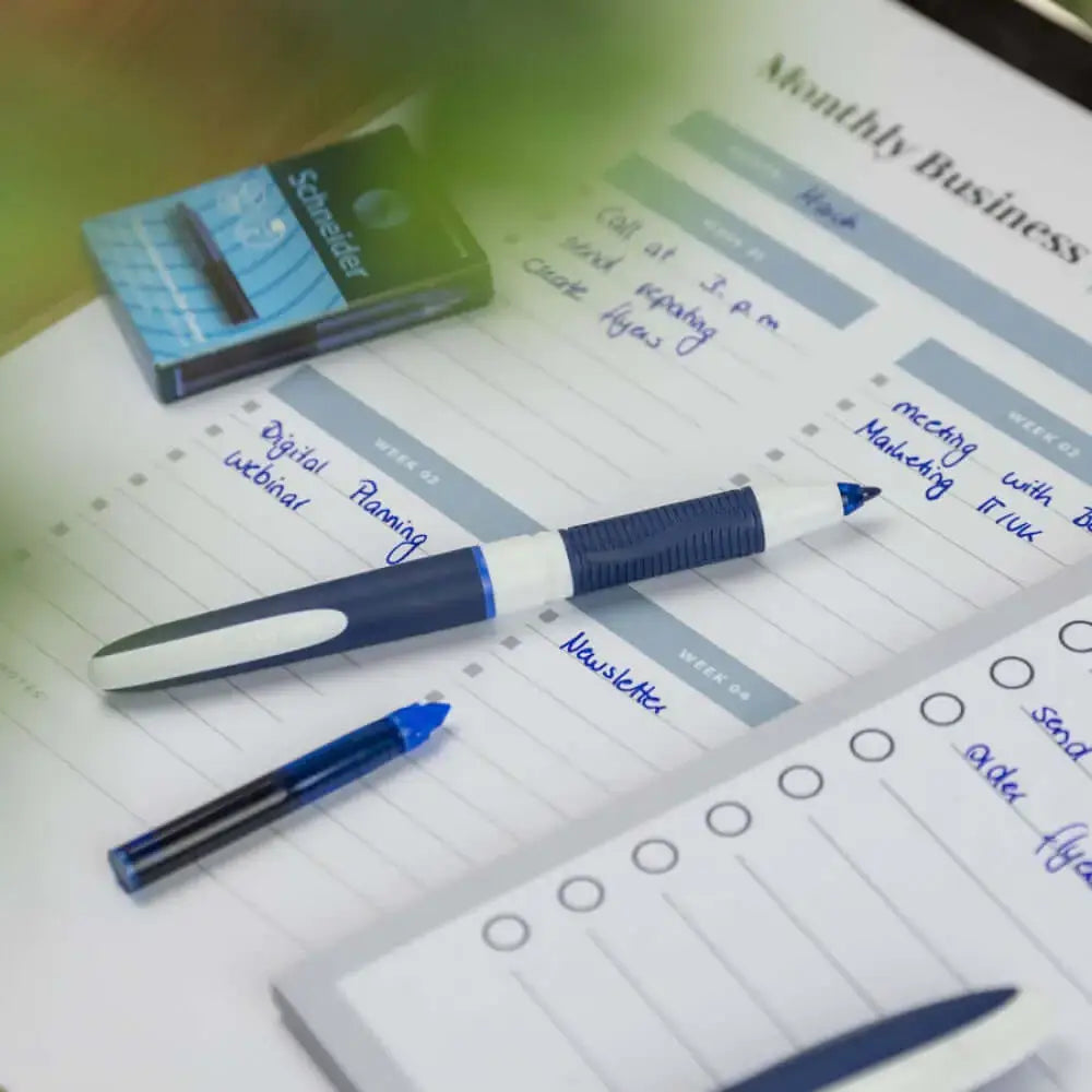 Schneider One Change 0.6 MM Roller Ball Pen on a monthly business planner with blue ink.