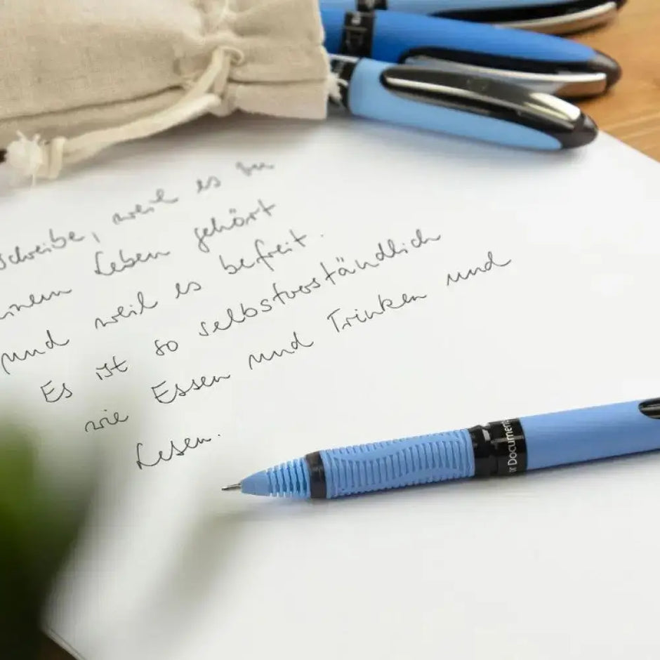 Schneider One Hybrid N MM Roller Ball Pen writing on paper with handwritten notes beside other pens.