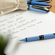 Schneider One Hybrid N MM Roller Ball Pen writing on paper with handwritten notes beside other pens.