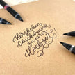 Schneider One Sign 0.8 MM Roller Ball Pen used for elegant handwriting on kraft paper for wedding wishes.